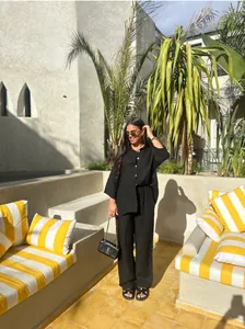 Femme portant un ensemble décontracté deux pièces en coton et lin noir dans un décor ensoleillé
