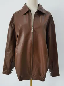 Detailed view of an oversized brown faux leather motorcycle jacket on a white mannequin.
