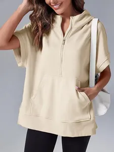 Close-up of beige short-sleeve hoodie featuring half-zip and front kangaroo pocket detail