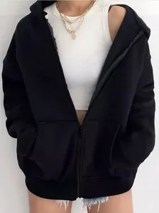 Detalle de la sudadera con capucha y cremallera negra con top blanco