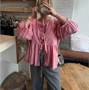 European style pink puff sleeve shirt with tie-front detail in a cafe setting