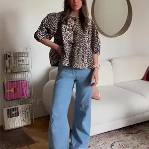 Fashionable leopard print blouse with bubble sleeves and tie-neck details on model