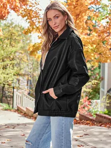 Stylish oversized black faux leather moto jacket for women worn in an autumn outdoor scene.
