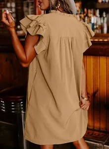 Detailed back view of a khaki ruffle sleeve mini dress in a cozy rustic bar setting.