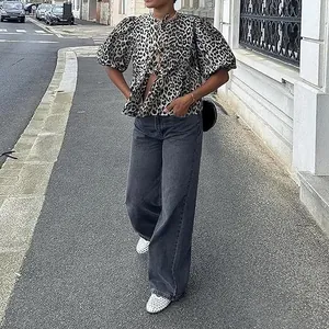 Stylish model in leopard print puff sleeve tie-front blouse and wide-leg jeans on the street