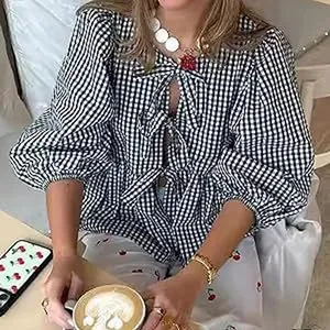 Detail view of a black and white gingham blouse with sweet tie-up and puff sleeves