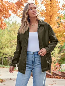 Close-up of olive green oversized faux leather biker jacket worn outdoors in autumn.