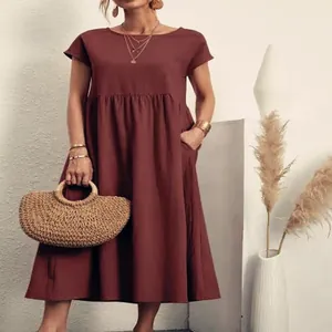 Dettaglio ravvicinato di un abito midi ampio in cotone e lino bordeaux con tasche