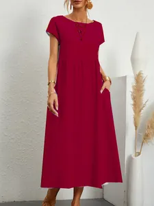 Vista dettagliata di un abito lungo rosso in cotone e lino con vestibilità ampia e tasche.
