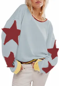 Vue détaillée d'un sweat-shirt bleu clair oversize avec des patchs d'étoiles rouges