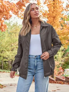 Outdoor lifestyle shot of a woman in an oversized brown faux leather biker jacket in autumn