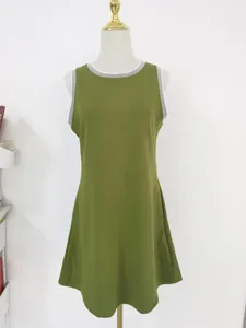 Detail eines ärmellosen olivgrünen Minikleides mit Streifenbesatz an einer Schuppe.
