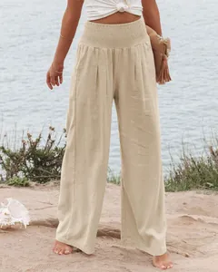 Lässige Damen-Hose mit hohem Bund und weitem Bein in einer sonnigen Strandumgebung.