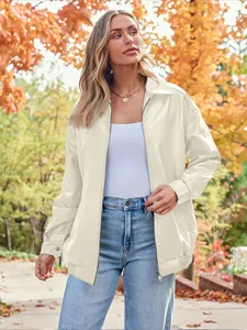 Oversized off-white faux leather biker jacket worn by model in an autumn outdoor park