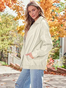 Side view of oversized women's cream motorcycle jacket in an autumn street setting.