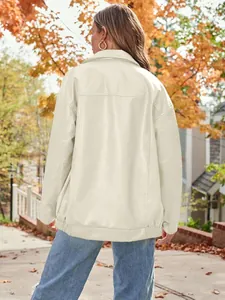 Back view of a women's oversized cream faux leather motorcycle jacket in an autumn setting
