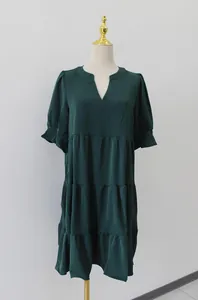 Vista frontal de un vestido verde oscuro con cuello en V en un soporte de maniquí alto.