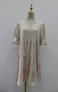 Vista detallada de vestido beige con cuello en V, volantes y mangas abullonadas