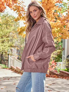 Side view of woman wearing oversized mauve leather biker jacket in autumn setting