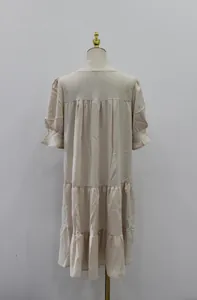 Vista trasera de un vestido midi beige con volantes y diseño de falda a capas en maniquí