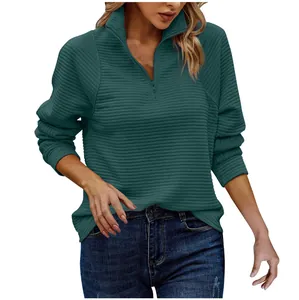 Close-up of women's ribbed sweatshirt showing forest green fabric and half-zip collar detail