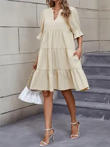 Elegante vestido beige con cuello en V, mangas abullonadas y bolsillos para el verano.