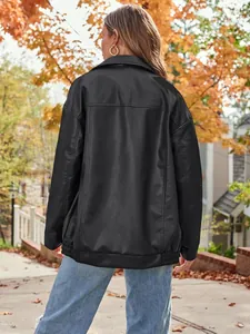 Back view of women's oversized black faux leather biker jacket in autumn street setting