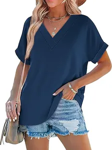 Detailopname van een marineblauwe zomertop met V-hals en omgeslagen mouwen op model.