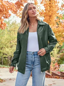 Detail of an oversized dark green faux leather moto jacket for women in an autumn setting