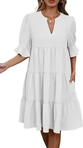 Detalle de un vestido de verano blanco con cuello en V, volantes y falda de capas