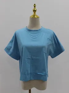 Dettaglio ravvicinato della t-shirt crop oversize azzurra con tasca e cuciture a vista