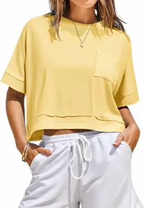 Detail of yellow oversized crop top t-shirt with front pocket and raw hem for summer casual wear.