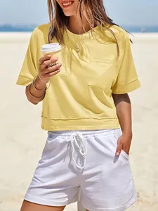 Modella che indossa un crop top t-shirt giallo oversize casual con tasca in spiaggia