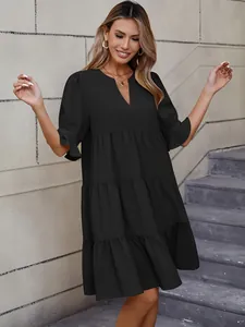 Elegante vestido corto negro con cuello en V y volantes usado por modelo de moda