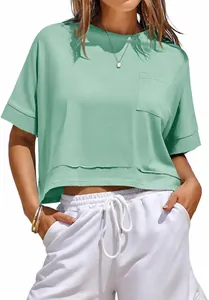 Detail view of mint green oversized crop top with chest pocket and raw edge hem.