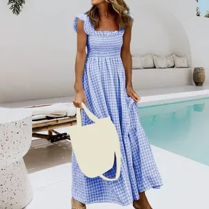 Full view of blue gingham smocked dress showing the ruffled straps and tiered skirt detail.