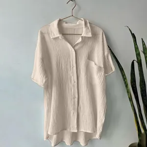 Detail of white cotton linen short-sleeve shirt showing soft crinkle texture and pocket