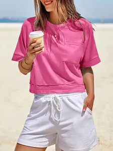 Dettaglio della t-shirt crop rosa oversize con taschino e pantaloncini bianchi estivi