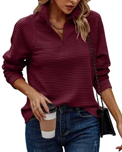 Close-up view of a burgundy ribbed sweatshirt featuring stand collar and zipper detail.