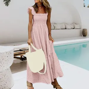 Detailed view of pink gingham maxi dress featuring smocked bodice and ruffle straps