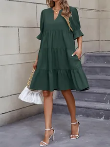 Vista completa de un vestido corto holgado verde oscuro de capas y cuello en V moda