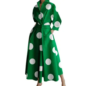 Elegante abito lungo verde a pois bianchi con maniche lunghe, un colletto e tasche