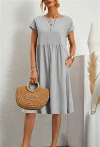 Dettaglio di un abito a trapezio in cotone grigio chiaro con scollo tondo e tasche laterali