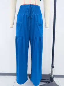 Front view of blue high-waisted cotton harem pants with drawstring and side pockets
