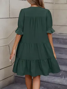 Vista trasera de un vestido casual suelto verde oscuro con capas y volantes