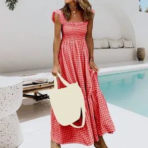 Detail of red and white gingham smocked maxi dress in a summer poolside setting