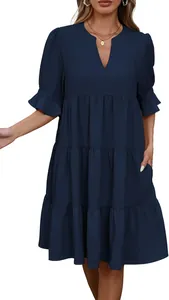 Vestido escalonado azul marino con cuello en V y mangas con volantes en una modelo.