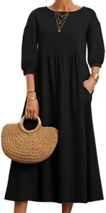 Loose fit women's black long-sleeve maxi dress with functional side pockets.