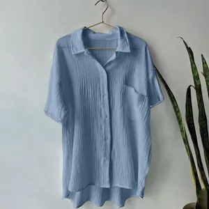 Detailed view of light blue cotton linen shirt showing textured fabric and pocket