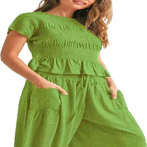 Detail of green two-piece women's casual outfit with smocked top and harem pants.